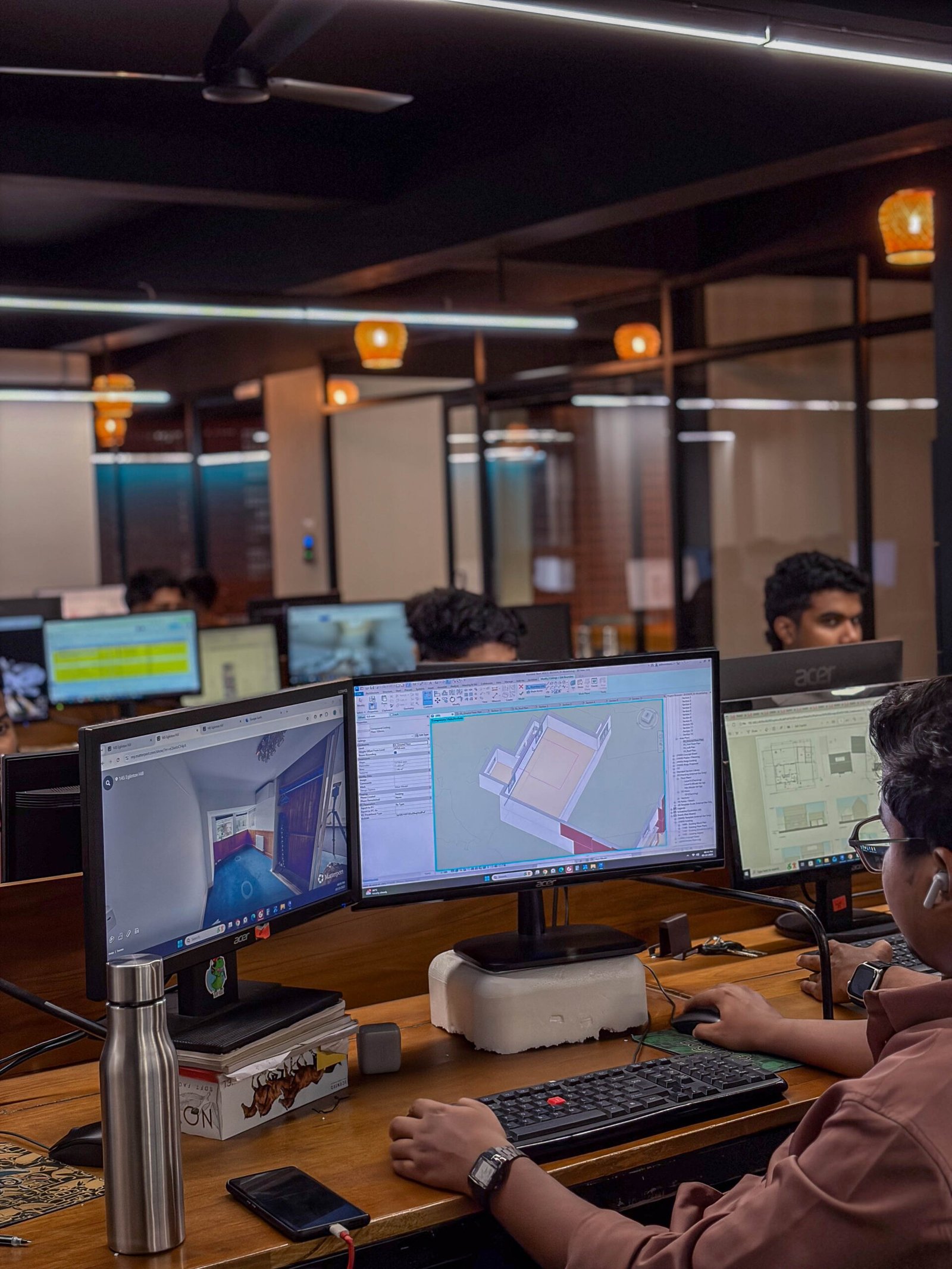 MJ Designs BIM specialist reviewing a Revit model and project information in the Manjeri office